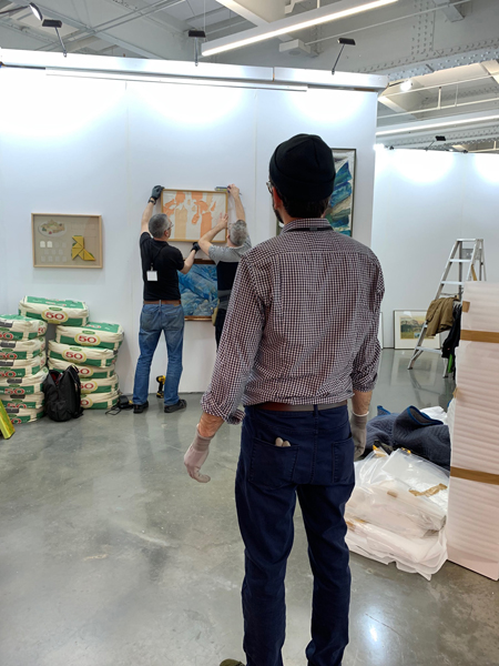 Claudio Marzano working with a team of art handlers to install a selection of artworks