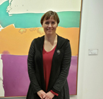 Nancy Smith standing in front of Janis Hoogstraten's painting